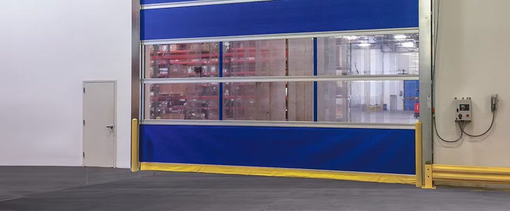 A blue high speed door is open in a warehouse