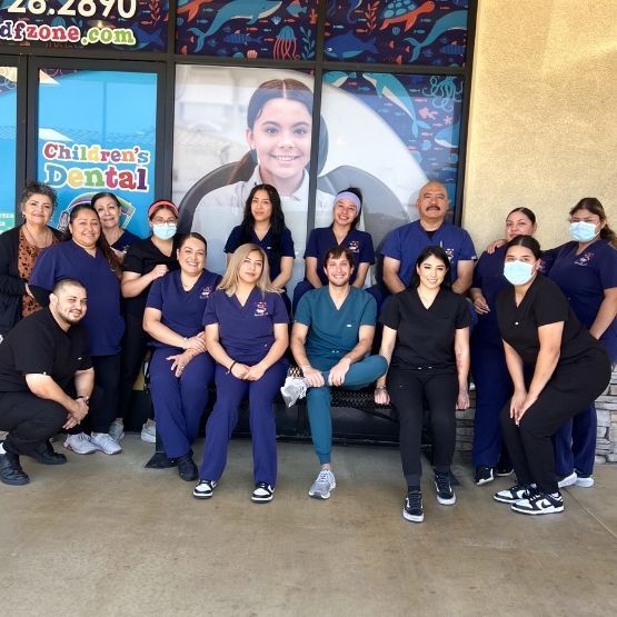 A sign for a children 's dental office is outside of a building.