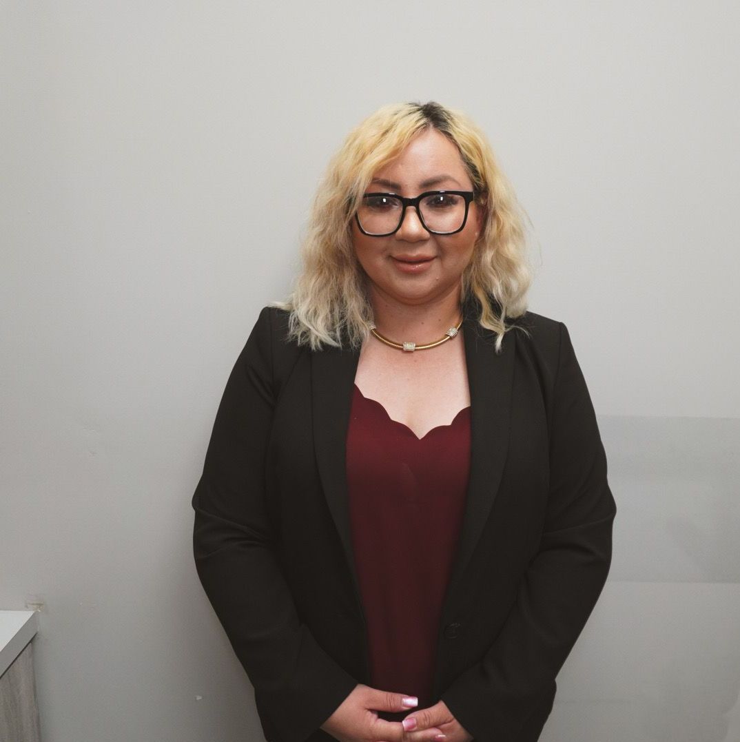 Blonde hair woman in black jacket and maroon shirt