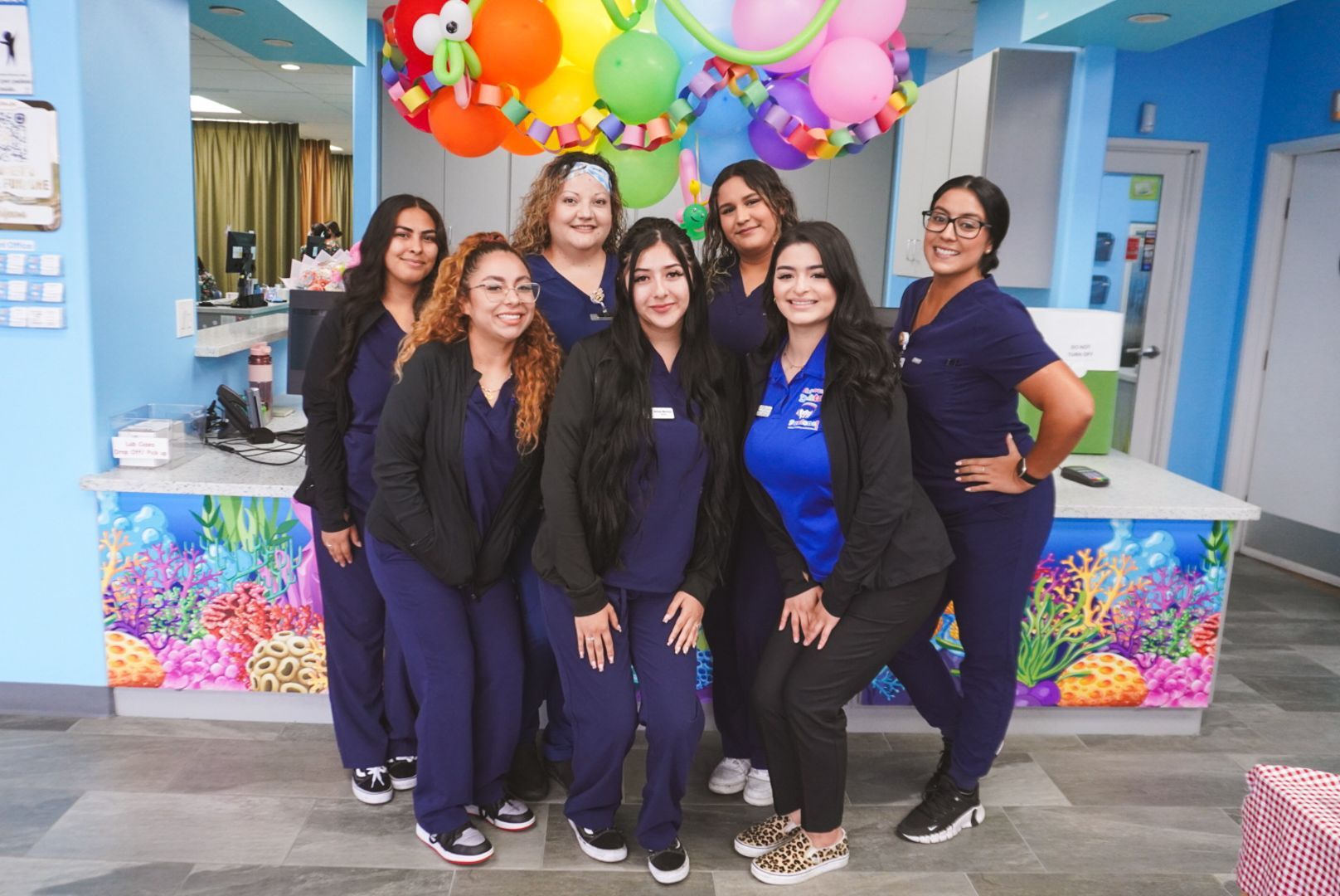 group of woman smiling at camera in dental office