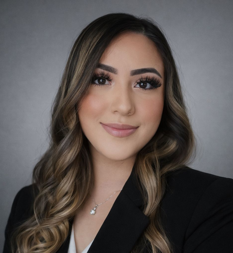 A woman with long hair is wearing a black shirt and smiling for the camera.
