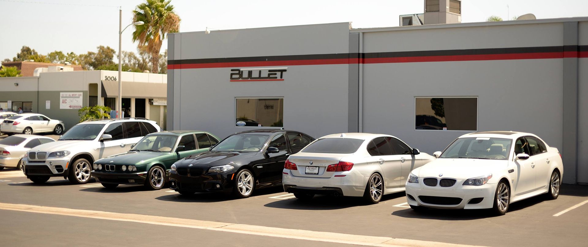 A row of cars are parked in front of a building.