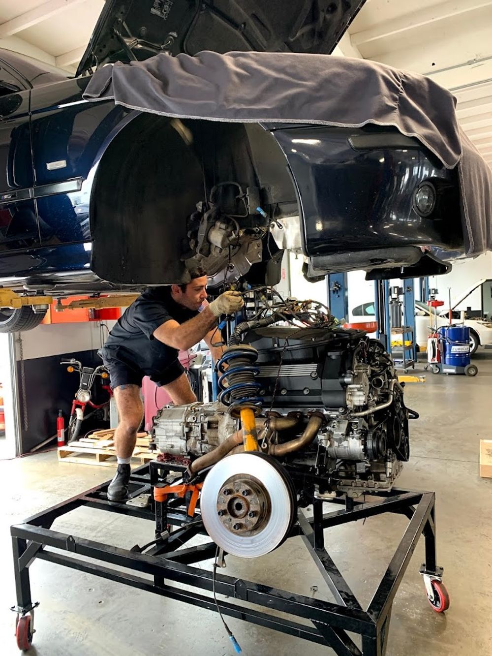 A man is working on a car engine in a garage.