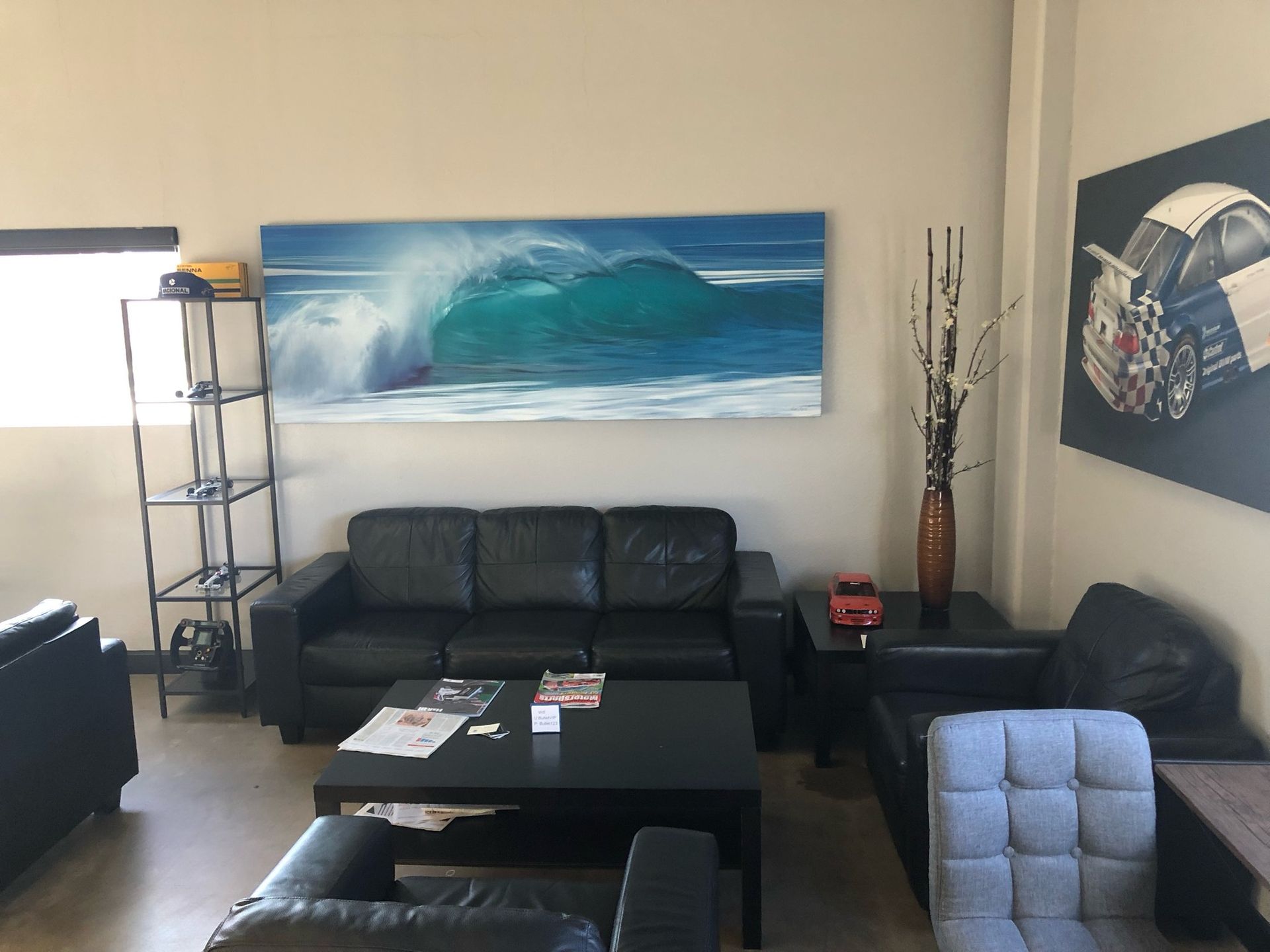A living room with a painting of a wave on the wall