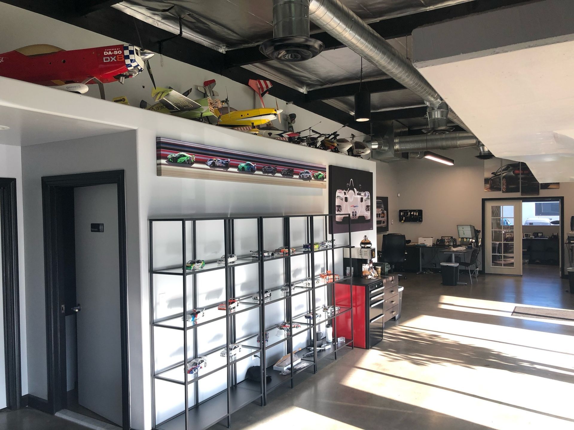 A room with a lot of shelves and a plane on the ceiling
