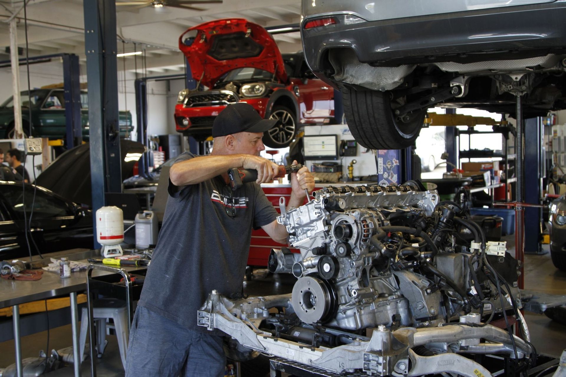 A man is working on a car engine in a garage
