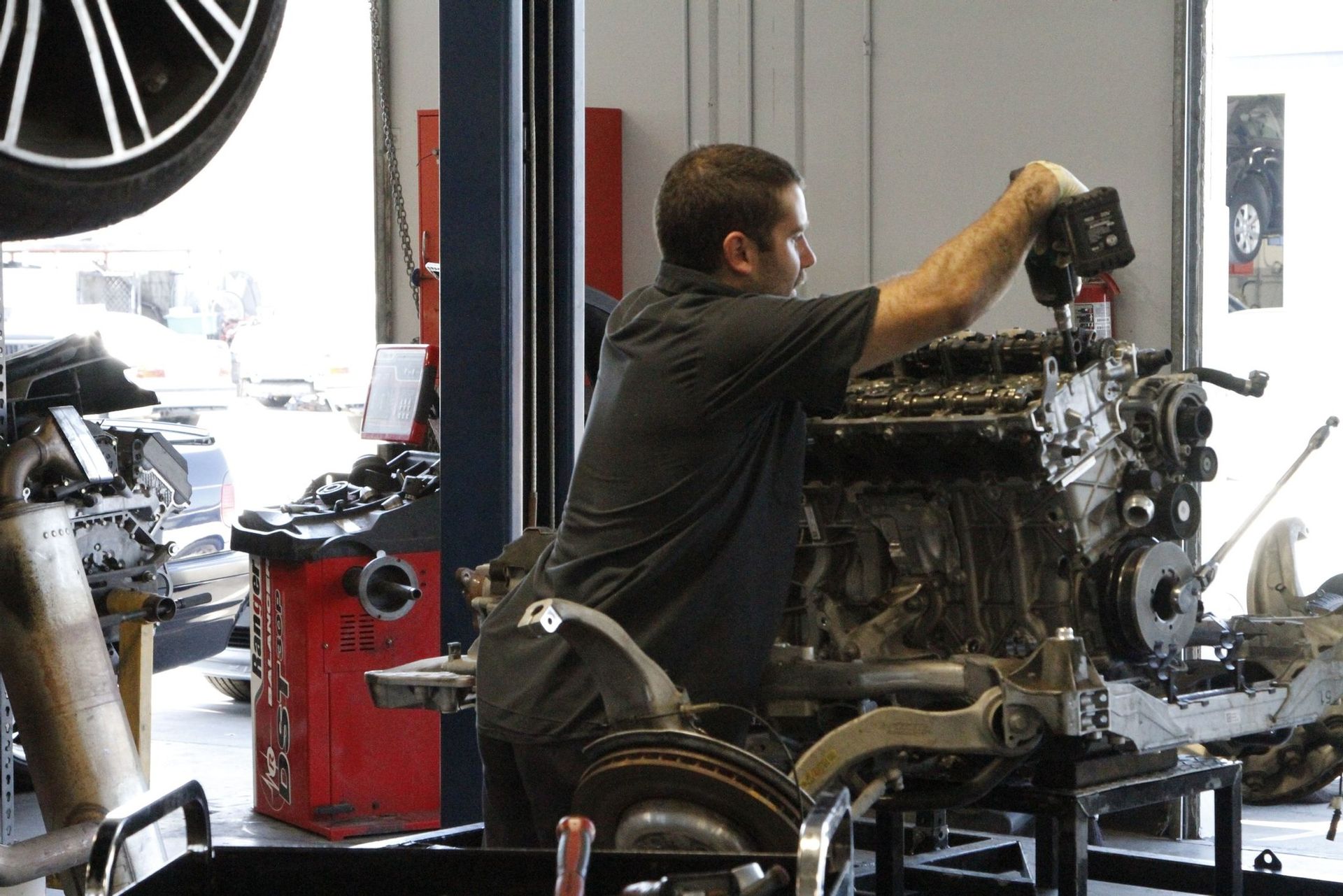 A man is working on a car engine in a garage
