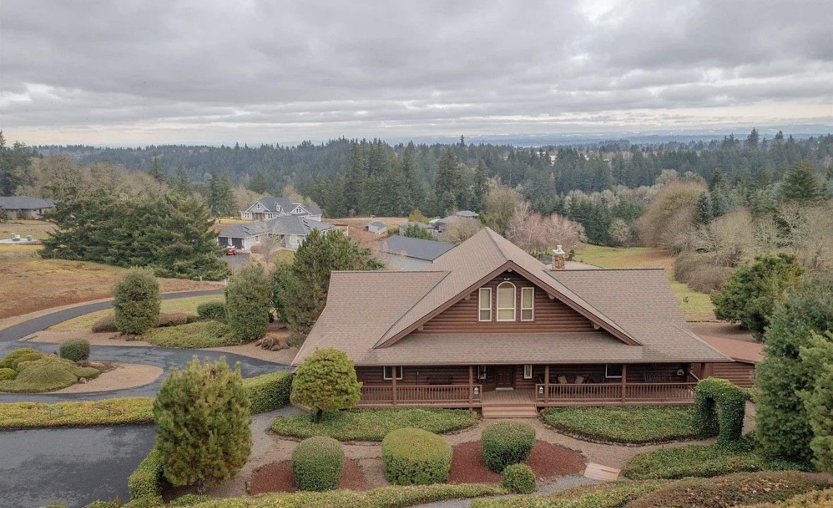 Single-story house with a brown roof in a landscaped suburban neighborhood under a cloudy sky