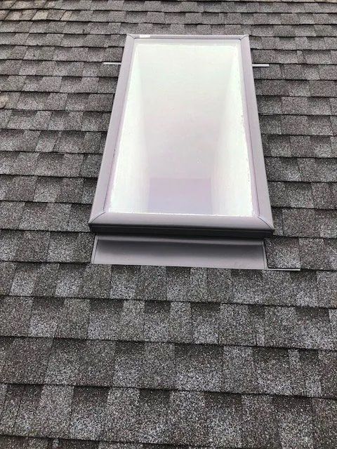 Roof skylight on gray shingled roof