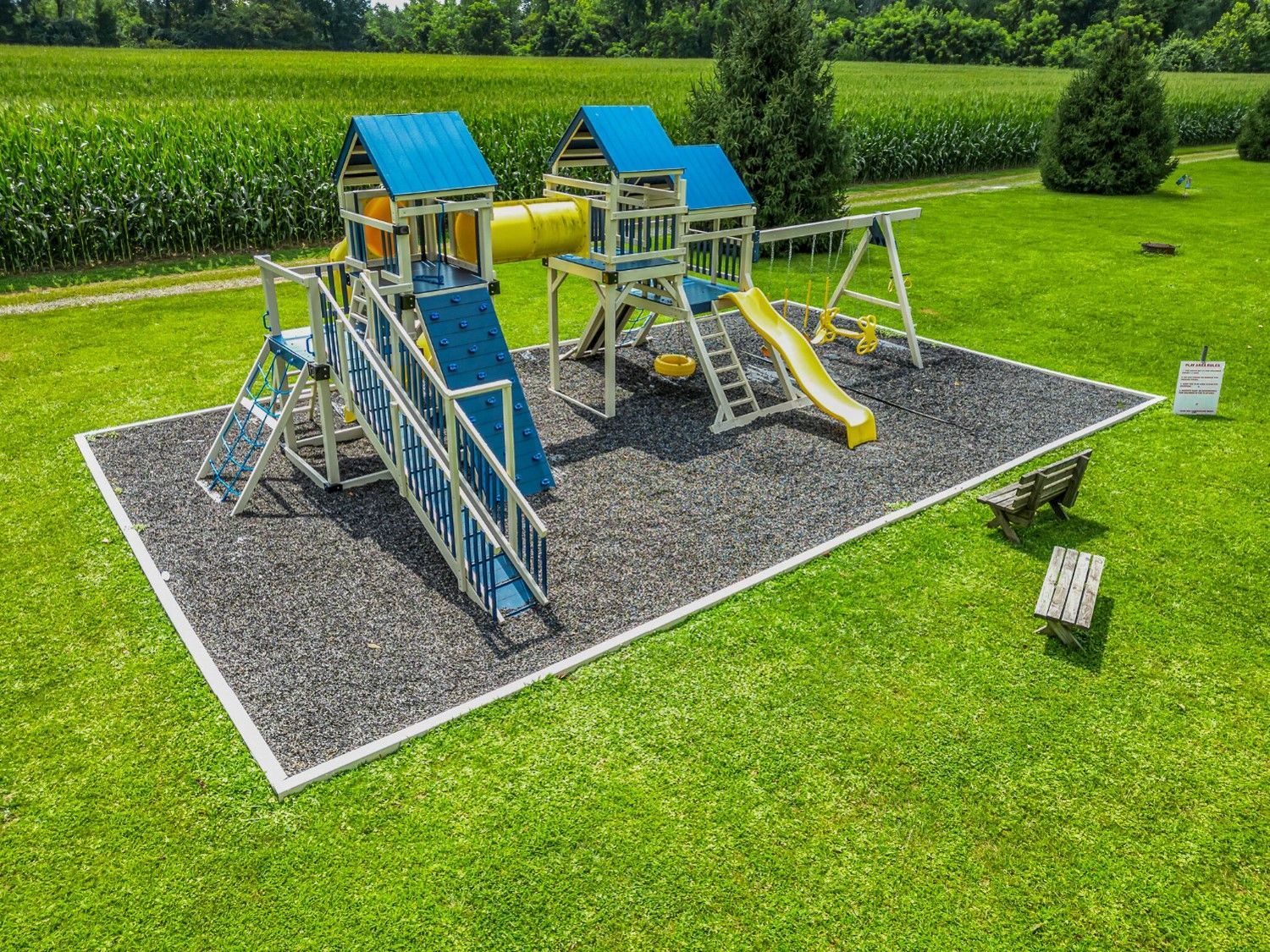 An aerial view of a playground set in the middle of a lush green field.