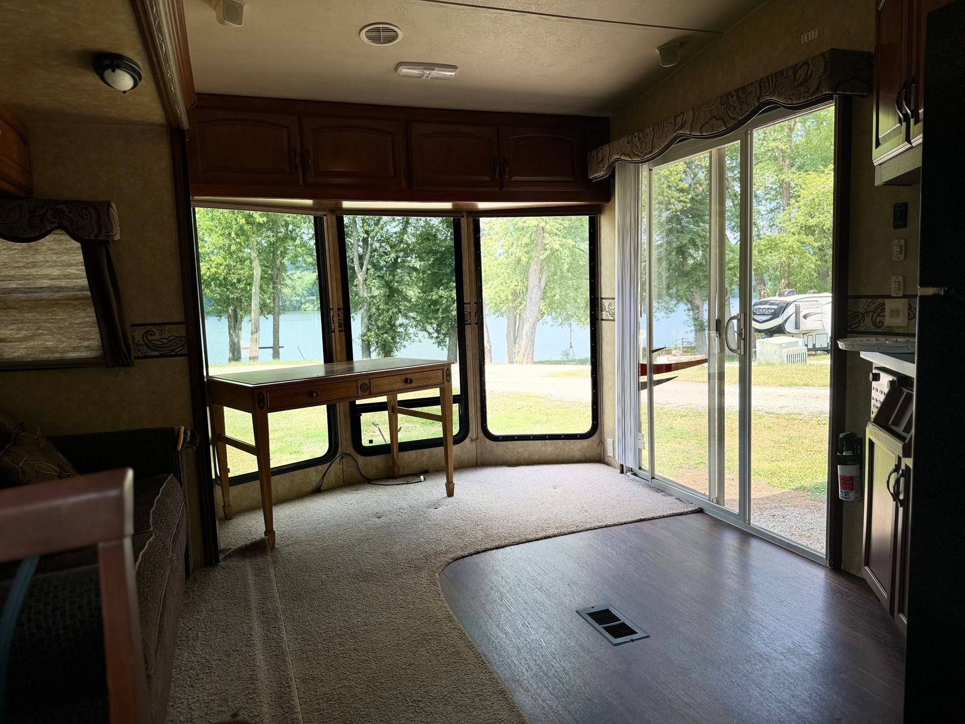 The inside of a rv with a lot of windows and sliding glass doors.