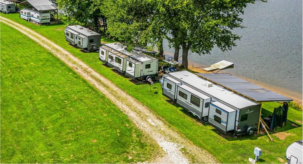 An aerial view of a row of trailers parked next to a lake.