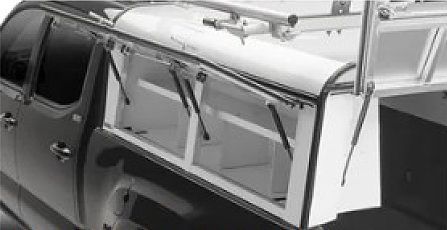 Black-and-white view of a truck cab with a metal roof rack and frame under construction