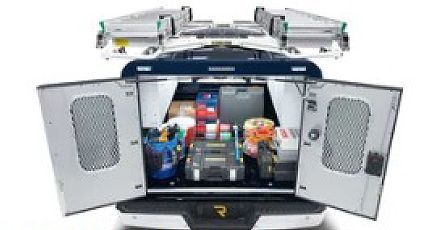 Open truck bed with organized cargo and storage bins, rear doors open, roof-mounted ladder rack visible