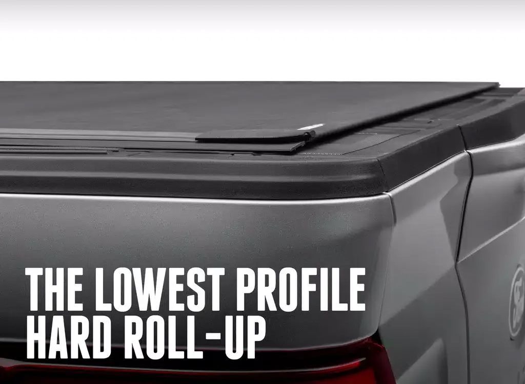 Silver pickup truck bed cover with text: THE LOWEST PROFILE HARD ROLL-UP