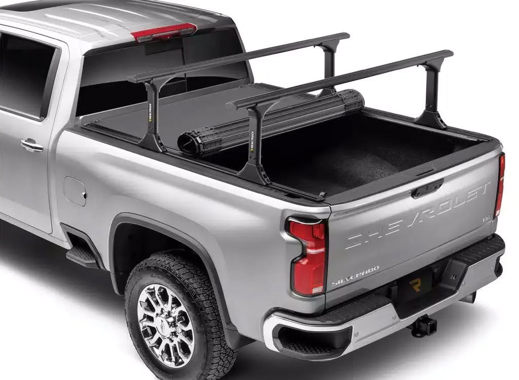 Silver pickup truck with bed rack and black cargo box, rear three-quarter view