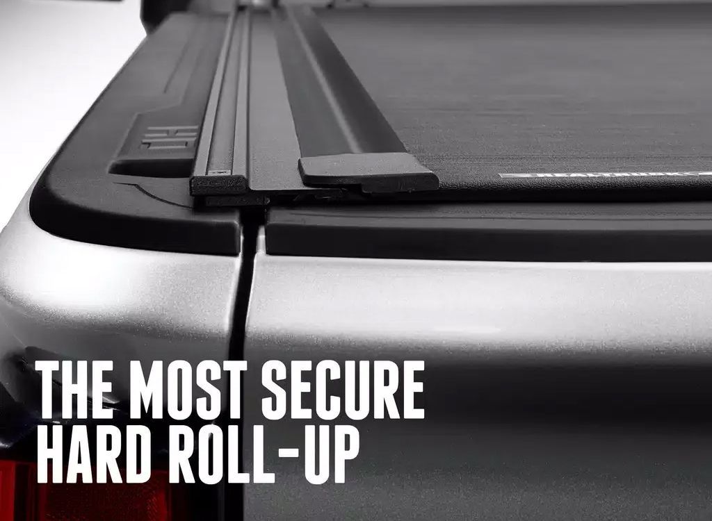 Close-up of a black hard roll-up truck bed cover with the text THE MOST SECURE HARD ROLL-UP