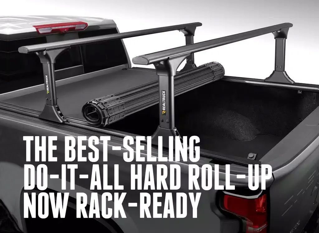 Pickup truck bed cover with rack system, text reads THE BEST-SELLING DO-IT-ALL HARD ROLL-UP NOW RACK-READY