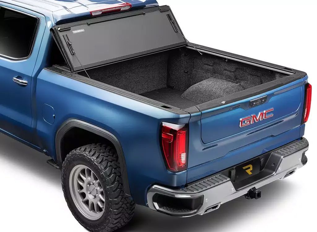 Blue pickup truck with open bed cover and rear tailgate, shown from the back-left side