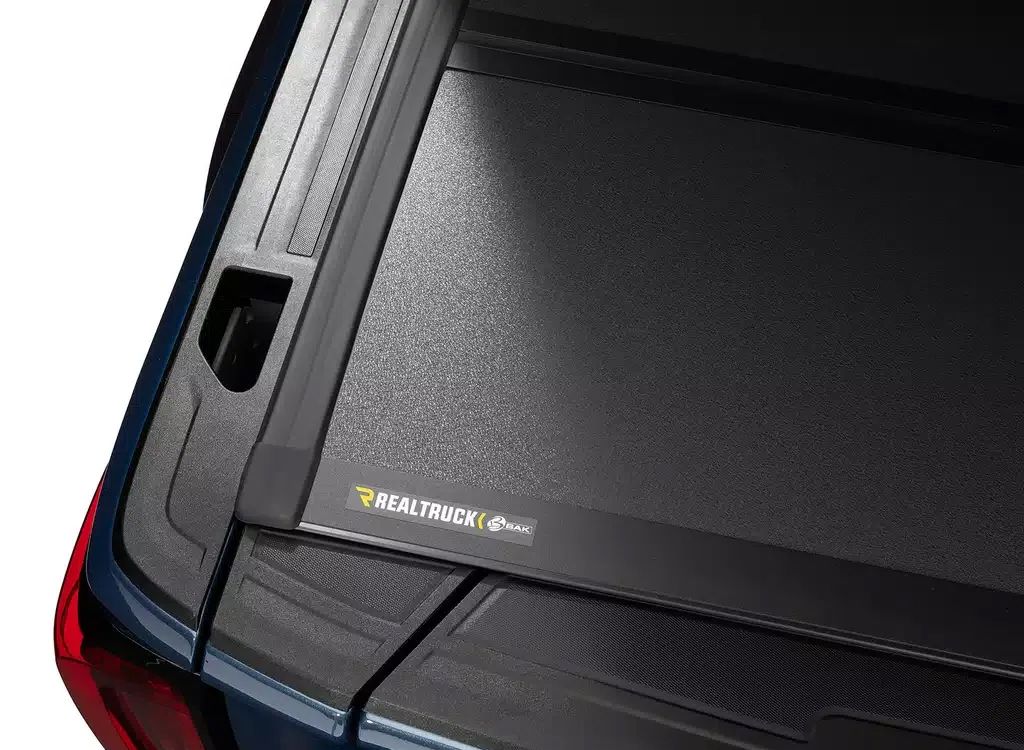 Close-up of a black-and-red car rear window with a small badge near the lower left corner