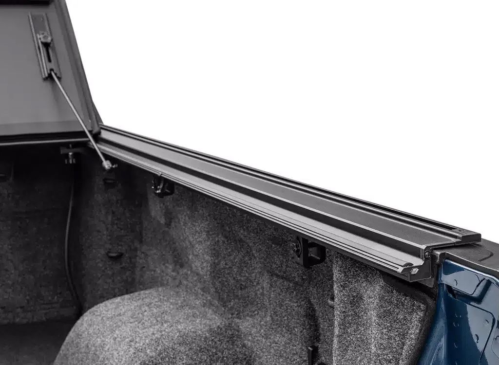 Truck bed with open tonneau cover and carpeted storage compartment