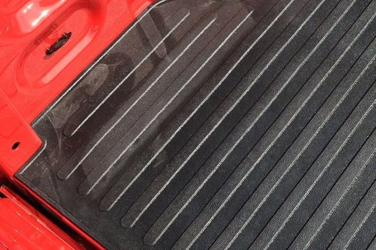 Red vehicle bed with a black ribbed liner and red side rails