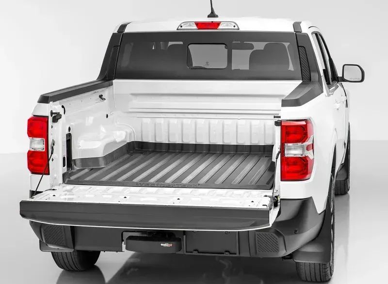 White pickup truck with open tailgate, showing empty cargo bed and rear view