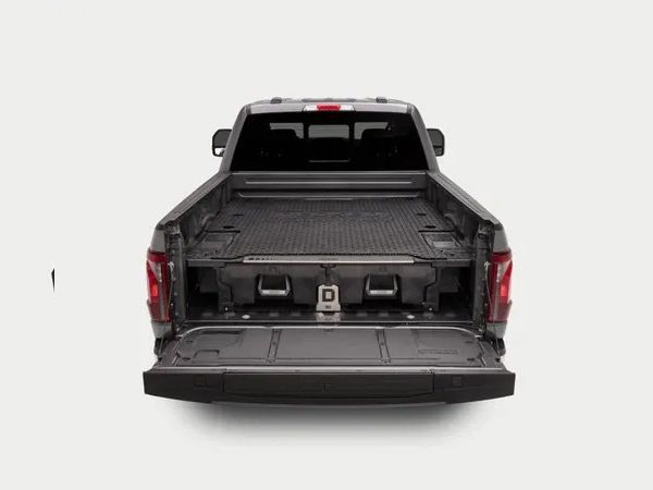 Rear view of a black pickup truck with the tailgate down, showing the empty cargo bed.
