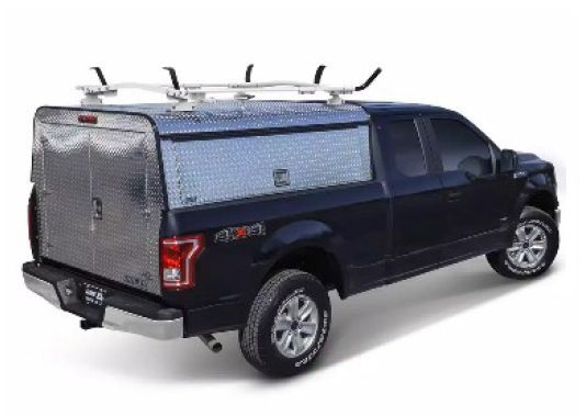 Dark blue pickup truck with a silver camper shell, side view on white background