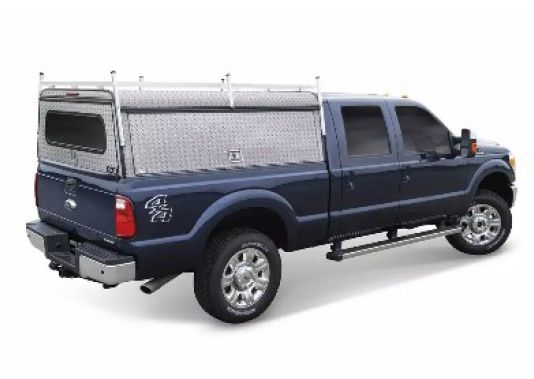 Blue pickup truck with silver camper shell, rear three-quarter view