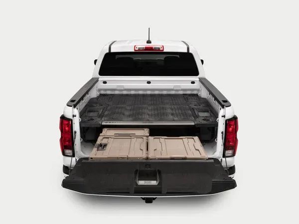 White pickup truck with tailgate down, showing the truck bed and cargo area.