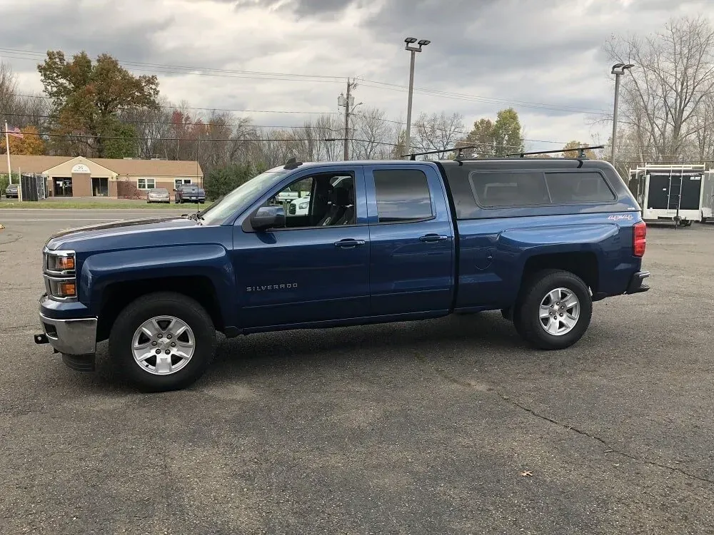 Blue pickup truck parked in a lot under a cloudy sky