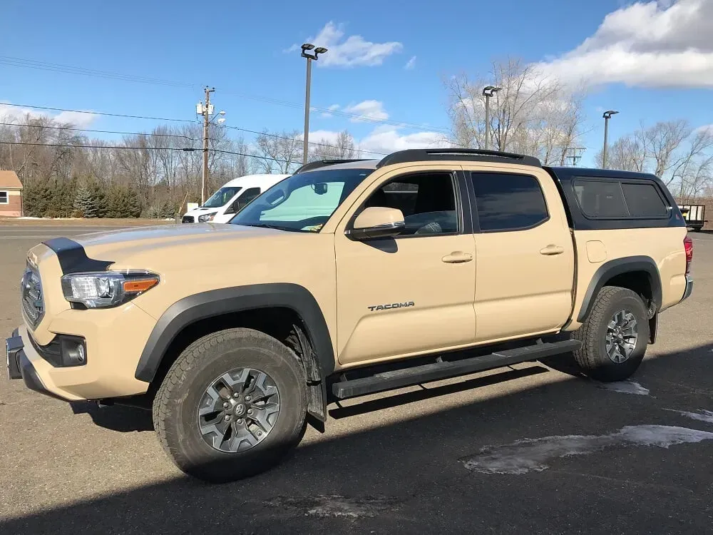 Tan pickup truck parked in a lot on a sunny day