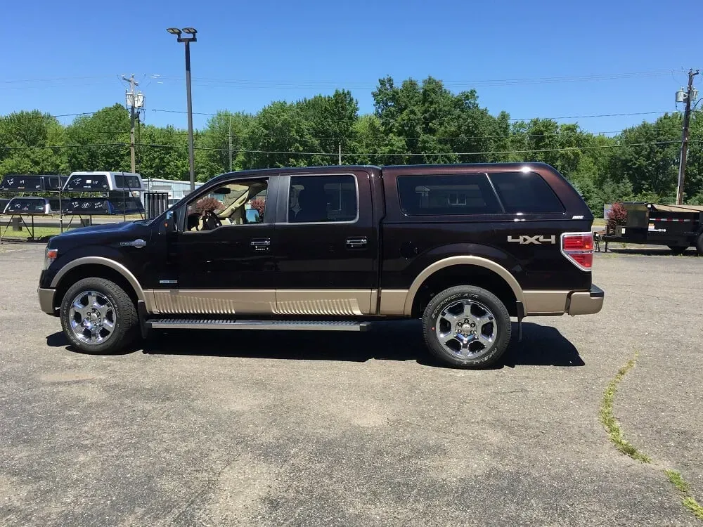 Black and tan pickup truck parked in a lot on a sunny day