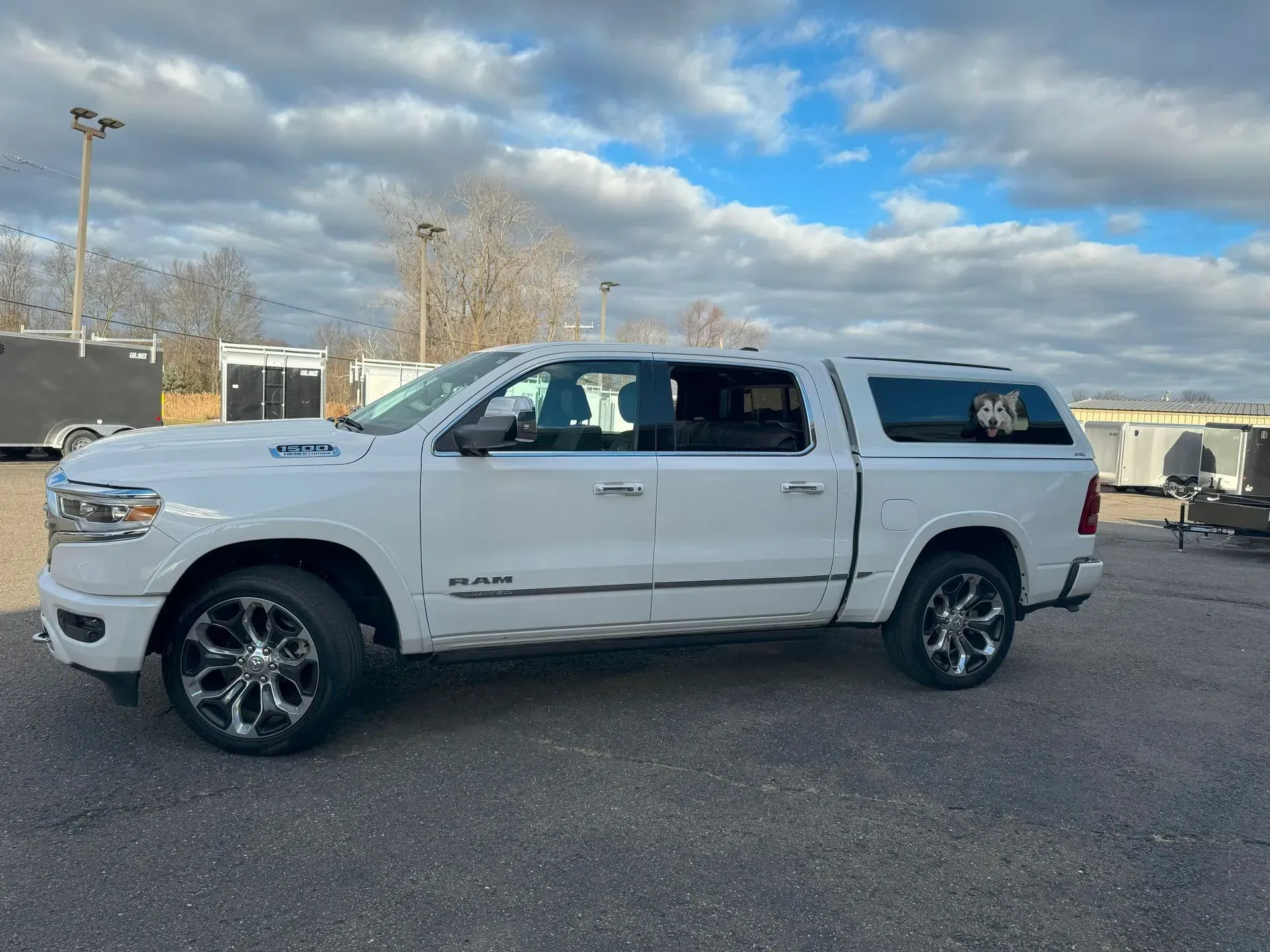 White pickup truck parked on pavement under a cloudy sky