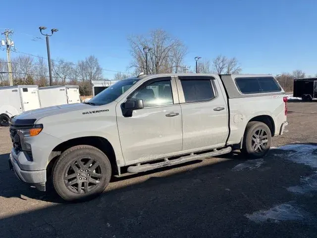 Silver pickup truck parked on a snowy lot under a clear blue sky
