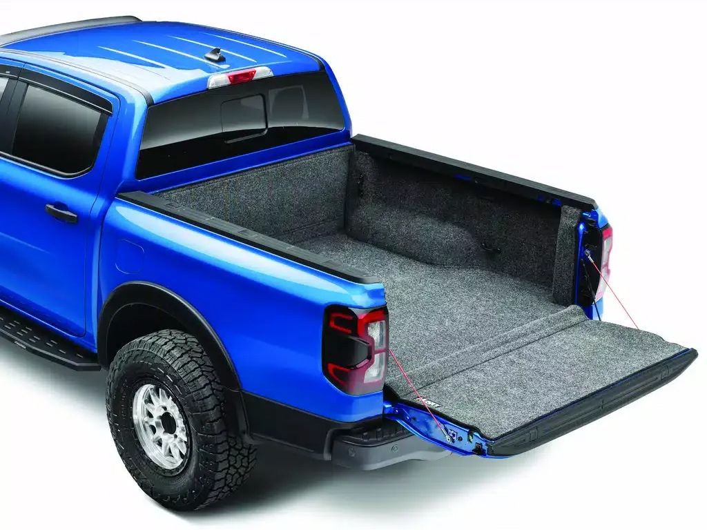 Blue pickup truck with an open tailgate and bed liner, shown from the rear side.