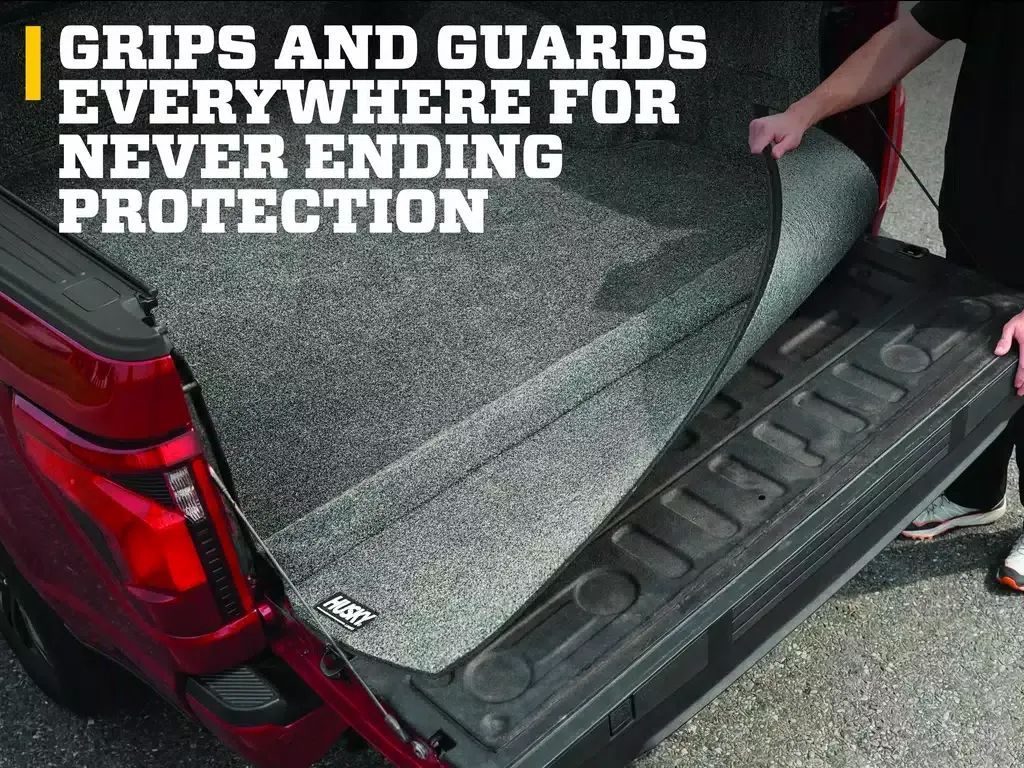 Red SUV cargo area with textured floor mats and black side step, overlaid with GRIPS AND GUARDS text