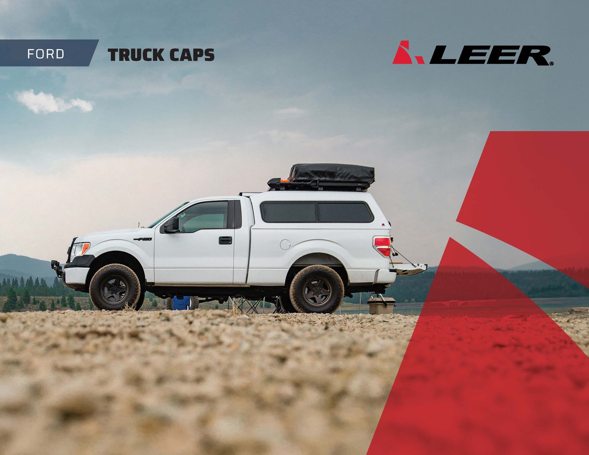 White Ford pickup with camper shell on rocky ground under blue sky, LEER truck caps branding above.