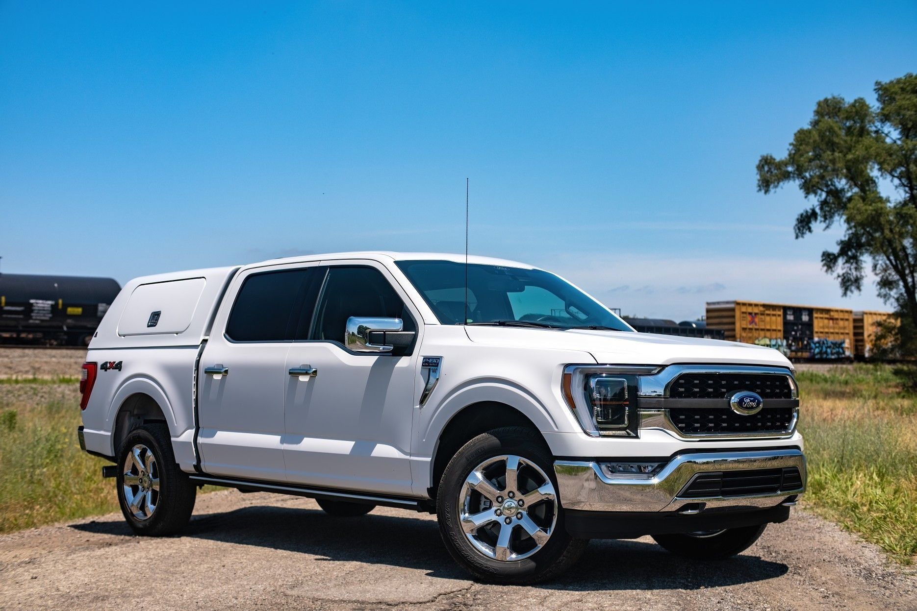 White pickup truck parked on grass under a blue sky