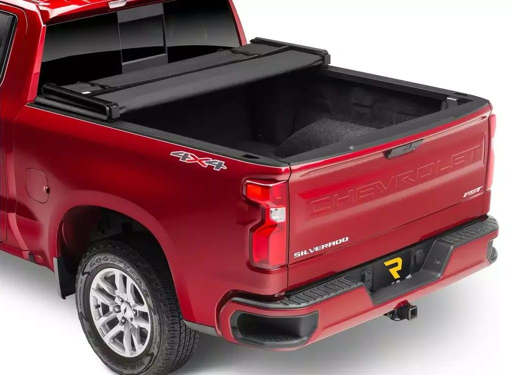 Red pickup truck with open bed and tailgate, shown from the rear on a white background