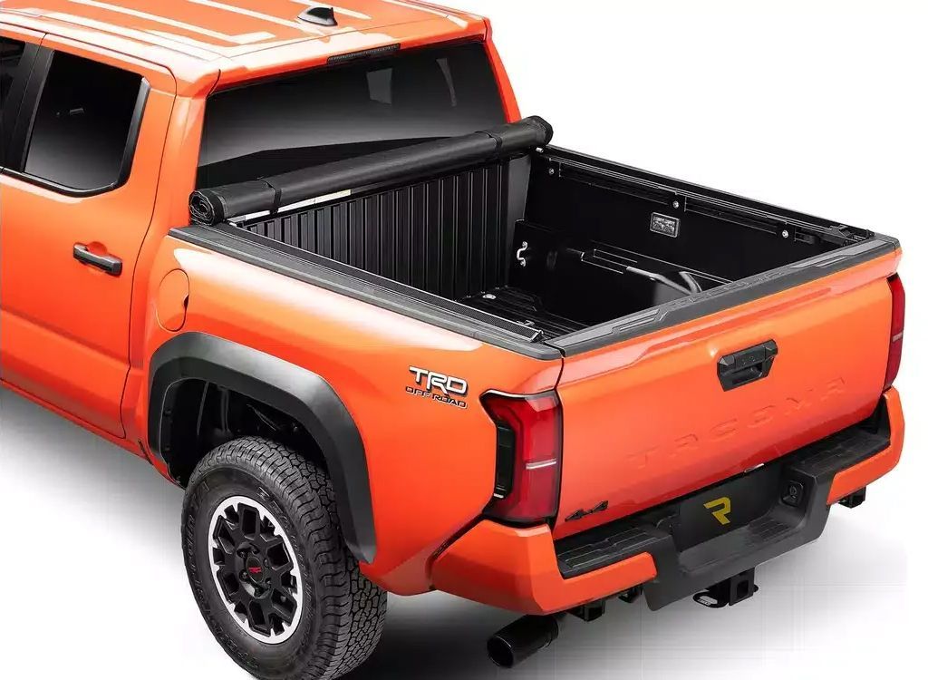 Orange pickup truck with black bed liner shown from the rear three-quarter view