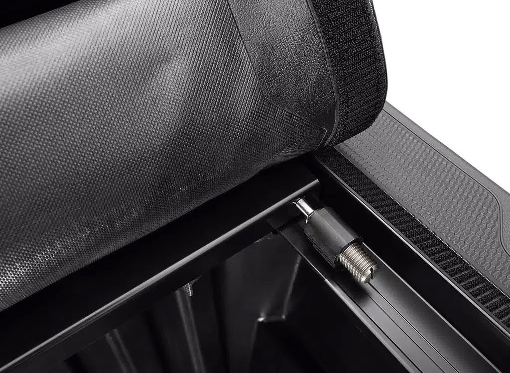 Close-up of a black fabric zipper pocket on a bag or case, showing the interior frame and latch area.