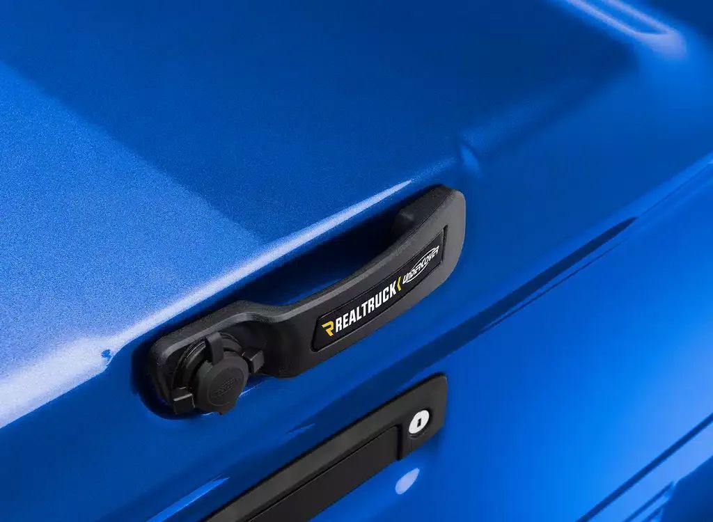 Close-up of a blue car door handle with keyless entry button and chrome accent