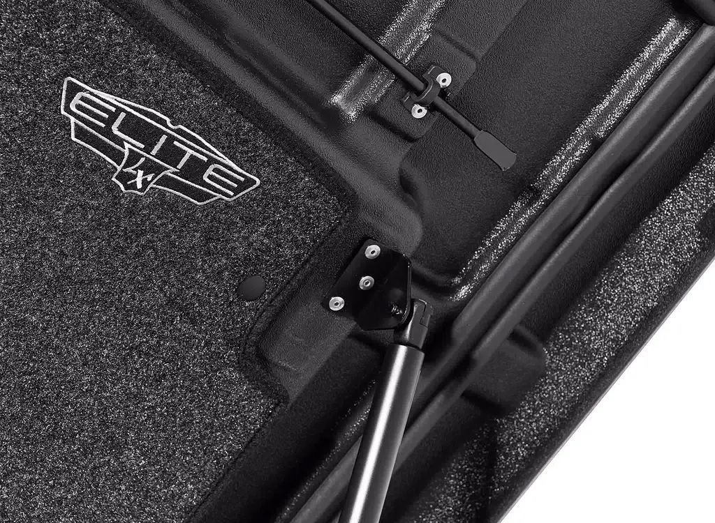 Close-up of a black umbrella frame and fabric underside with a metal hinge and support rod.