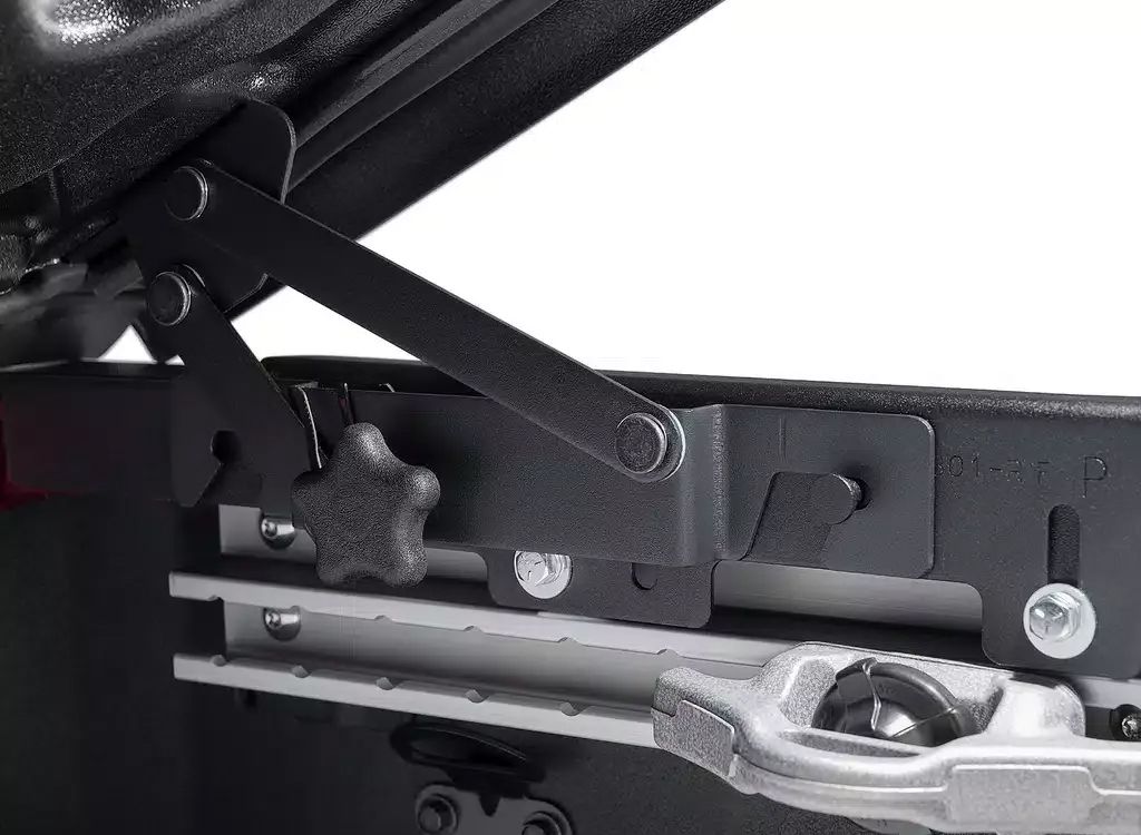 Close-up of a black seat adjustment mechanism with metal levers and a knob