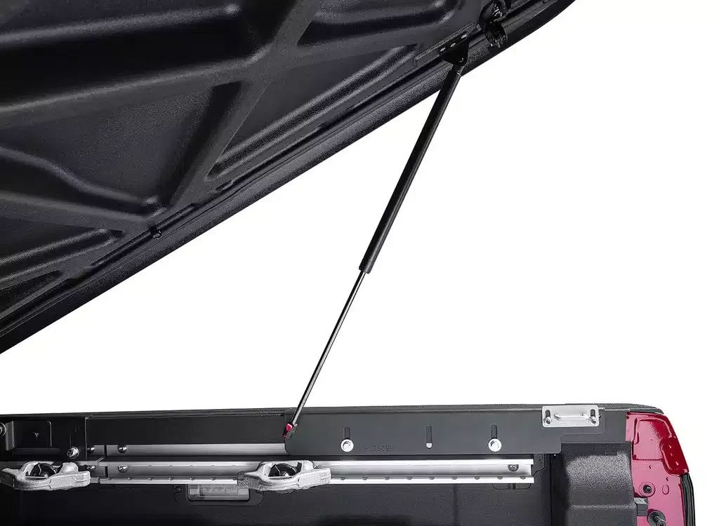 Open black car trunk with a support strut and red latch detail inside