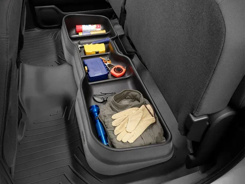 Car organizer with gloves, flashlight, tape, and small tools stored between car seats
