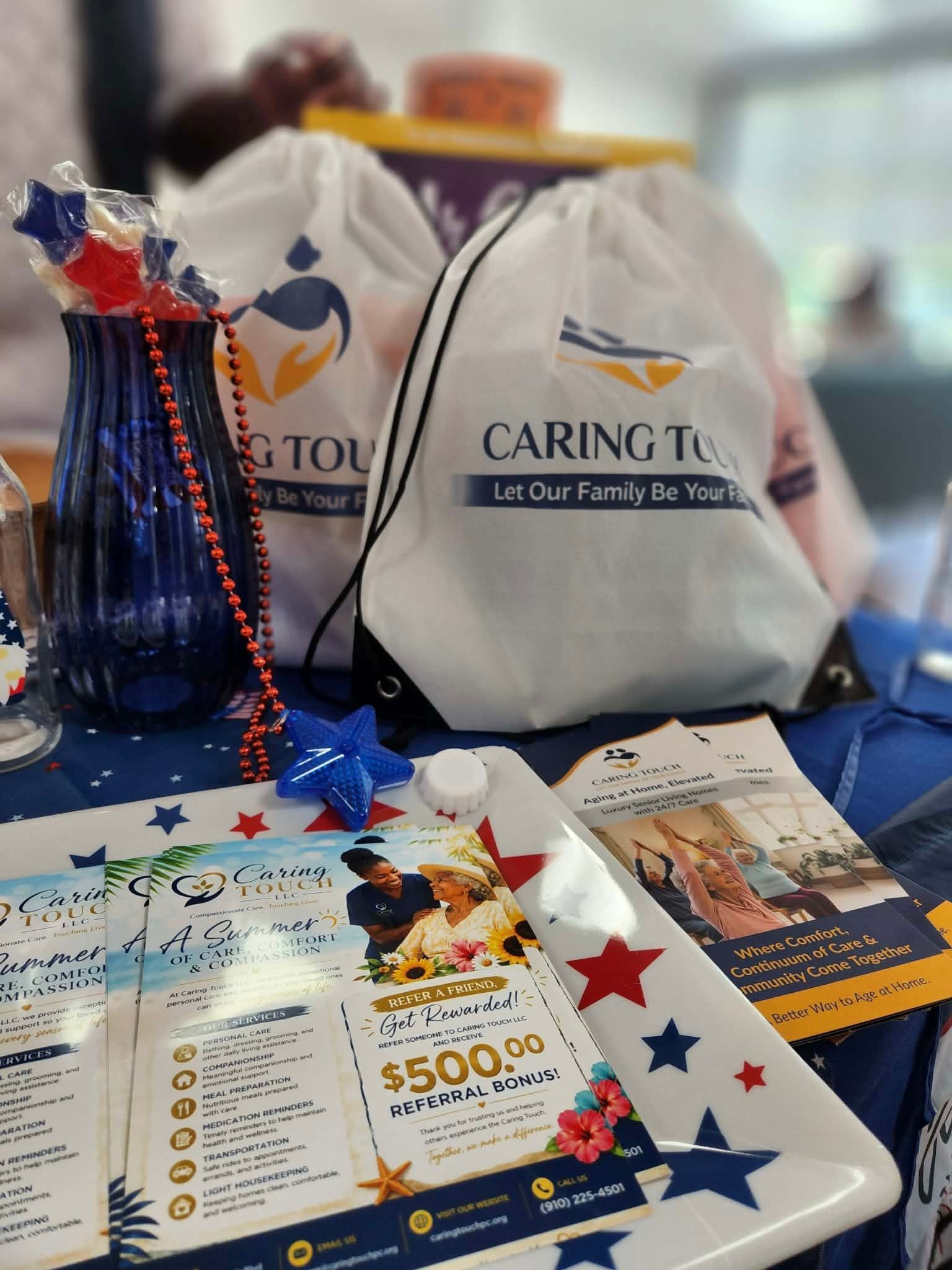 Prize table with gift bags, flyers, and a tray of raffle tickets decorated with red, white, and blue stars.