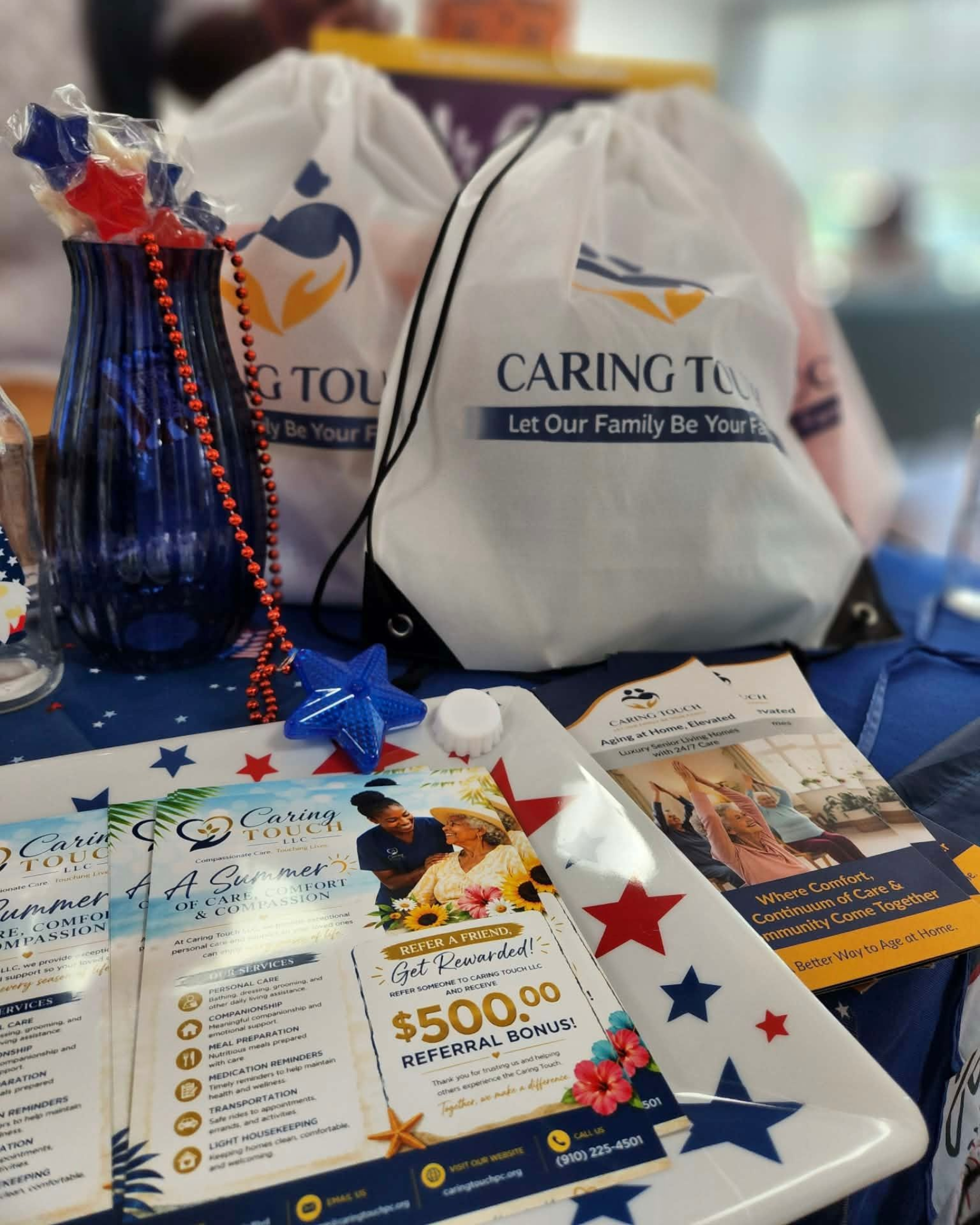 Prize table with gift bags, flyers, and a tray of raffle tickets decorated with red, white, and blue stars.